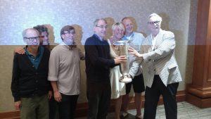 Het winnende team met van links af Martel, Moss, Grue, Fleisher, Auken, Welland, ACBL-president Ken Monzingo (Bridge Winners)